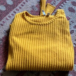 Yellow long sleeve shirt with a tie on the bottom.